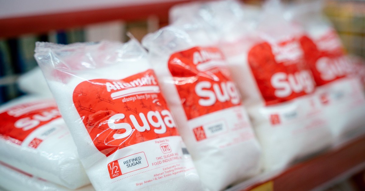 Close-up of sugar bags on a grocery store shelf, highlighting product packaging.