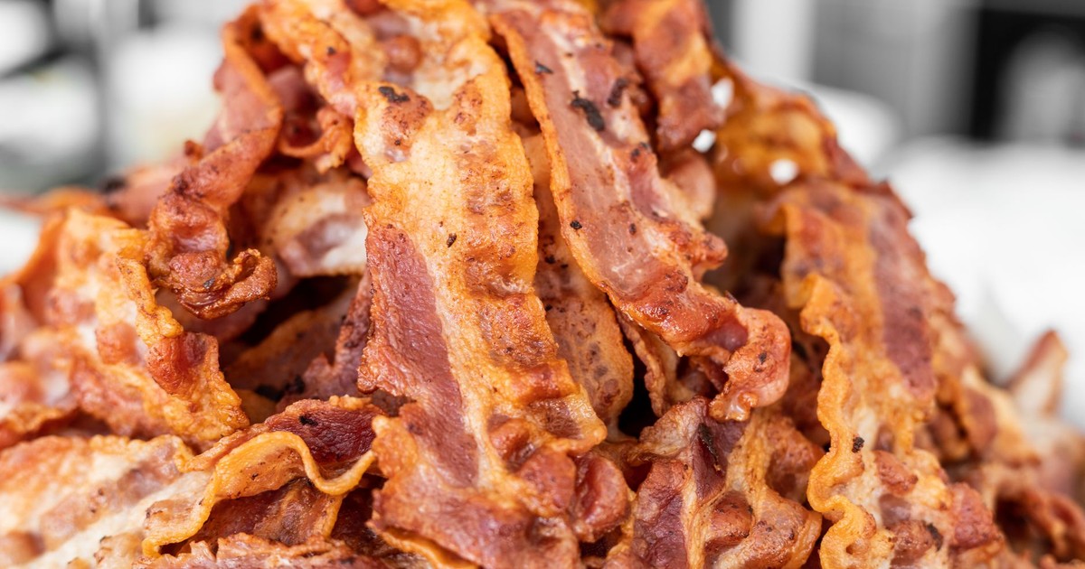 A heap of crispy cooked bacon strips on display, showcasing delicious texture and color.