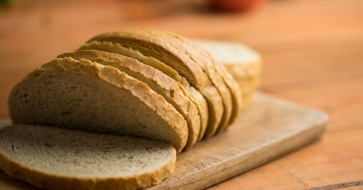 Close-up of sliced white bread on a rustic wooden board, capturing a homely and inviting look.