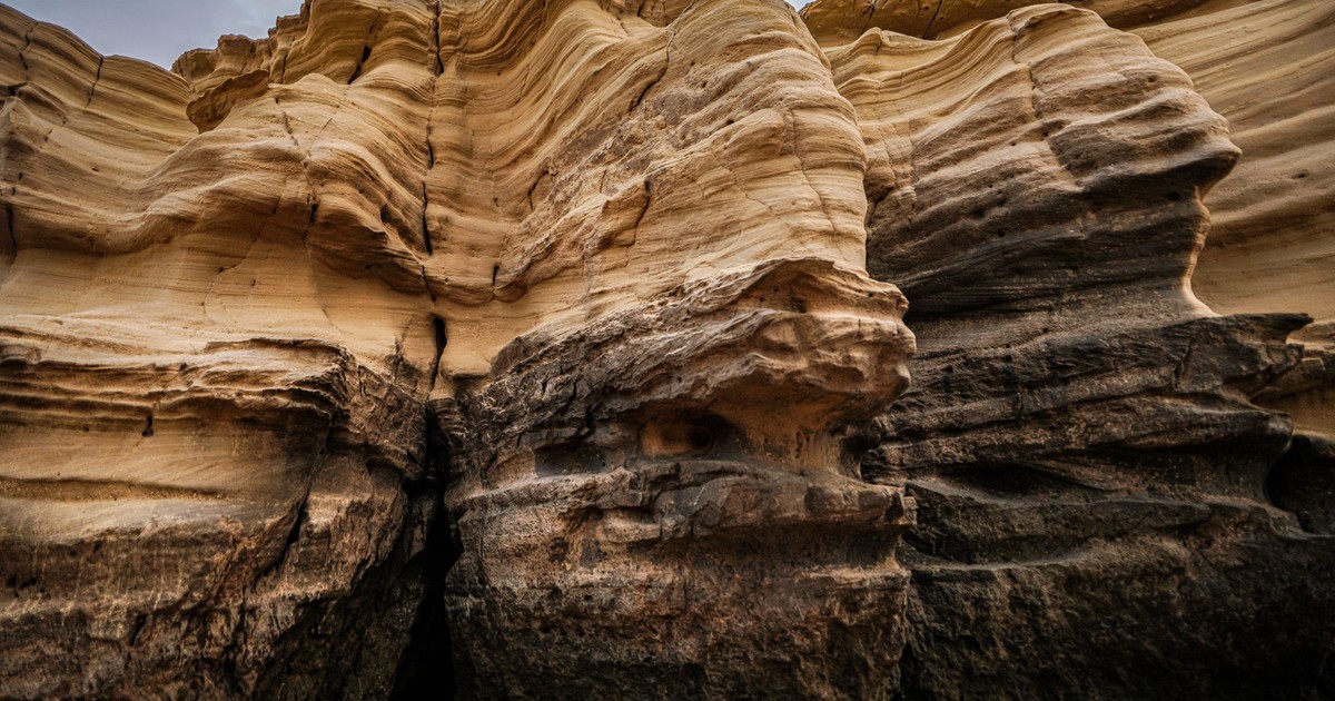 Close-up of layered sandstone formations in an arid landscape, showcasing natural erosion patterns.