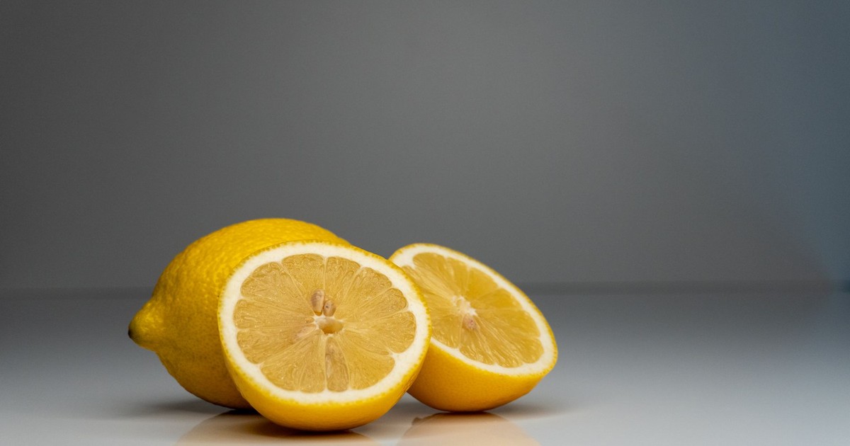 Vibrant yellow lemons sliced in half, showcasing fresh citrus in a studio setting.