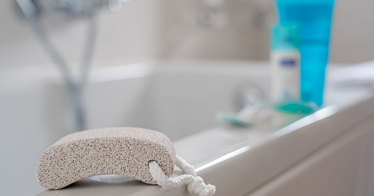 A pumice stone placed on a bathtub edge, ideal for foot care in a contemporary bathroom setting.