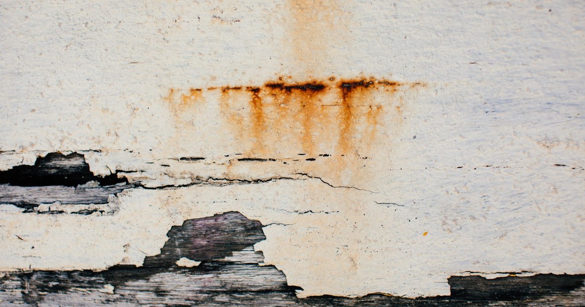 Textured background of weathered shabby cracked aged surface of old wall with plaster