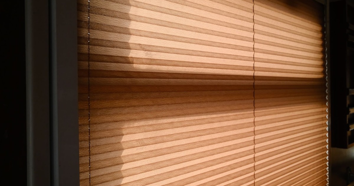 Sunlight streaming through blinds creating warm shadows in a room.