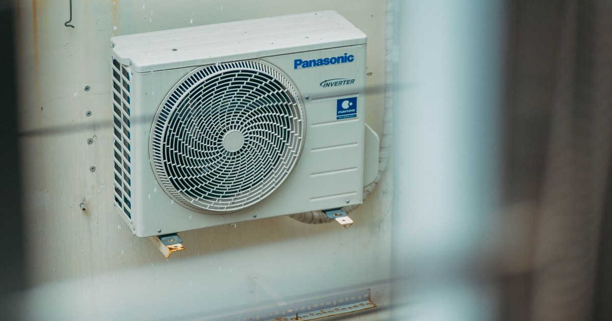 Air conditioner unit mounted outdoors on a building wall, showcasing modern HVAC technology.