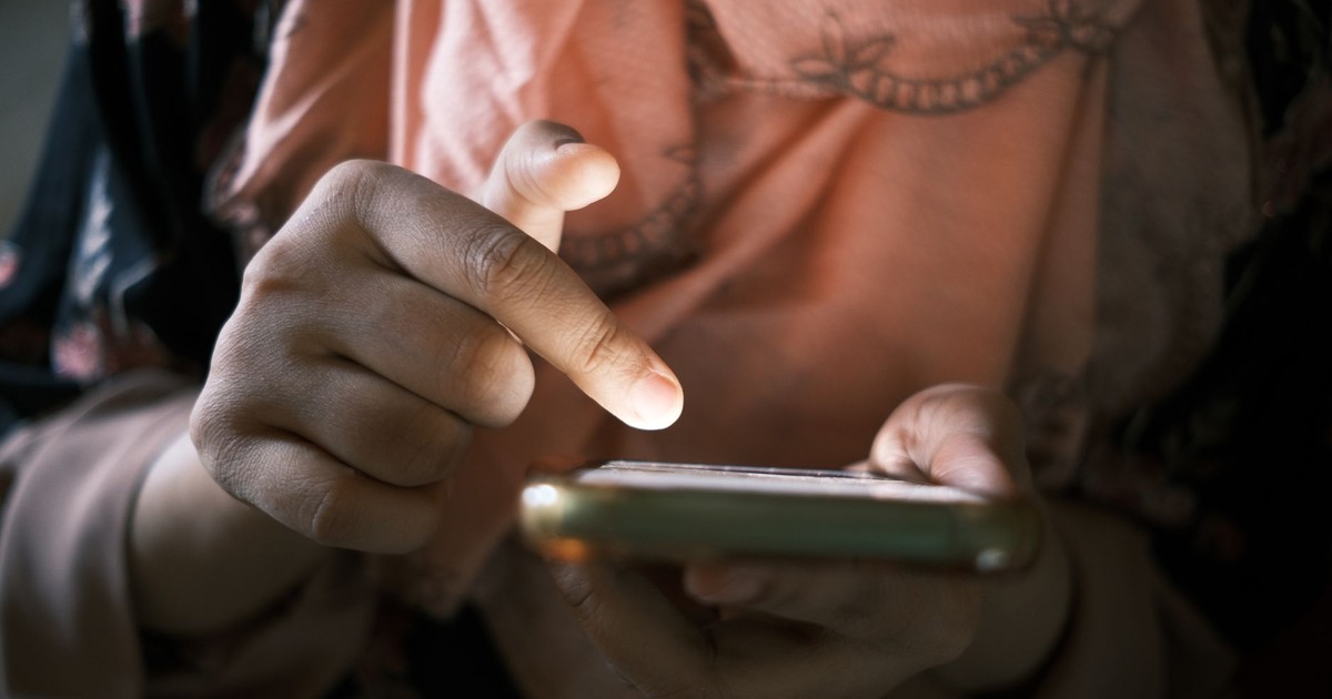 Close-up of hands using a smartphone indoors, highlighting touch technology.