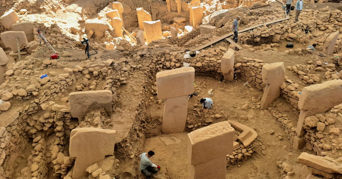Ancient archaeological site Göbekli Tepe under excavation, showcasing stone pillars and historical ruins.