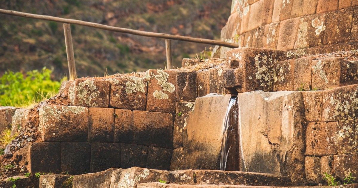 Explore the historic stone water channel in P'isac, Peru, showcasing ancient Incan engineering.