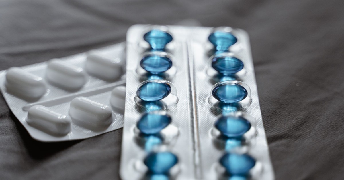 Detailed view of medication in blister packs showcasing blue softgel capsules and white pills.