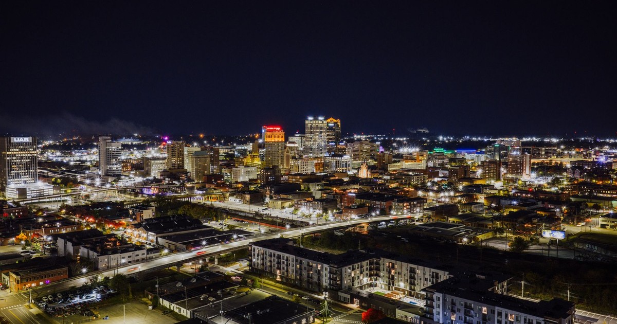 Stunning aerial night view of Birmingham, Alabama with illuminated cityscape and skyscrapers.