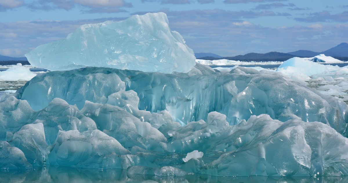 Stunning iceberg captured in clear Arctic waters, highlighting melting ice and climate change impact.