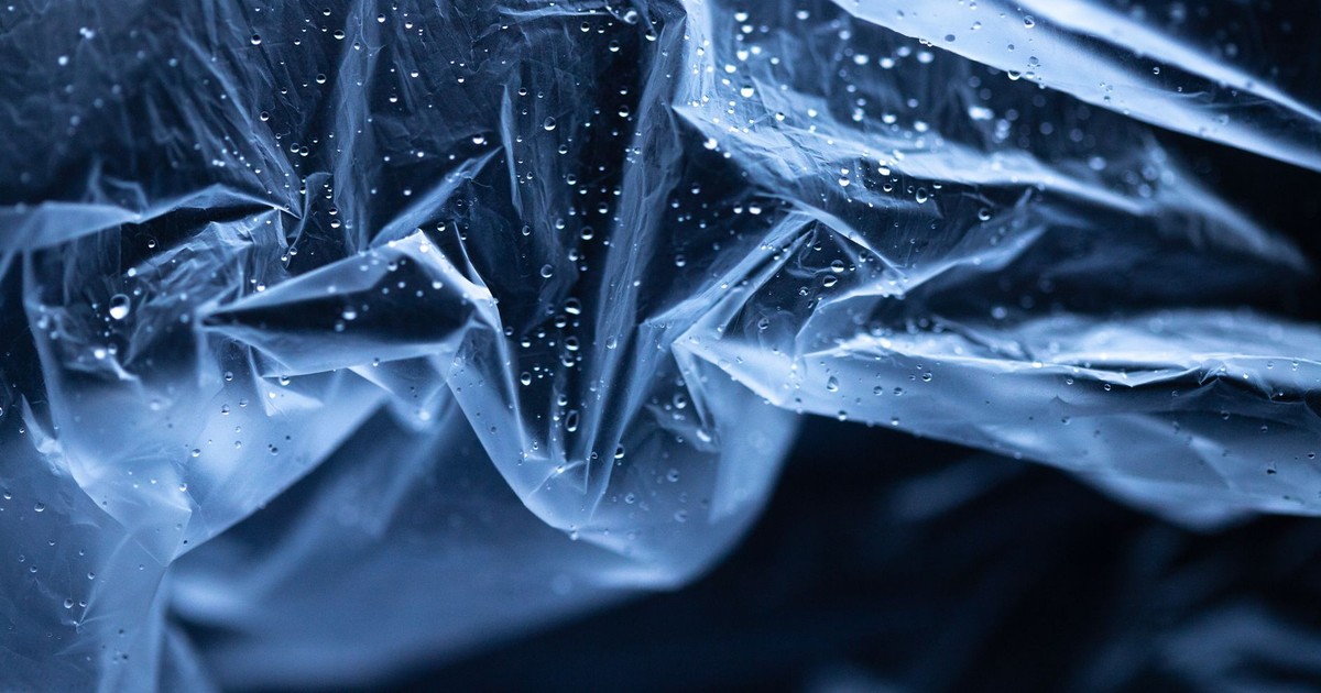 Abstract image of transparent plastic with water droplets. High contrast and cool tones enhance the texture.