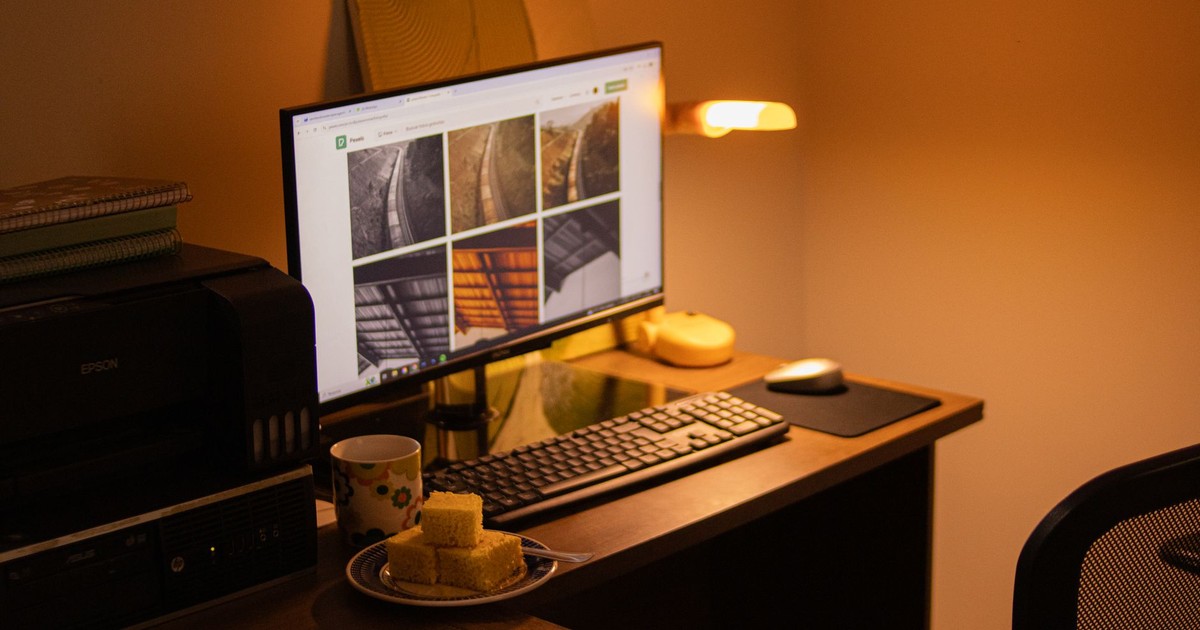 Warm-toned home office with computer setup, snacks, and ambient lighting.