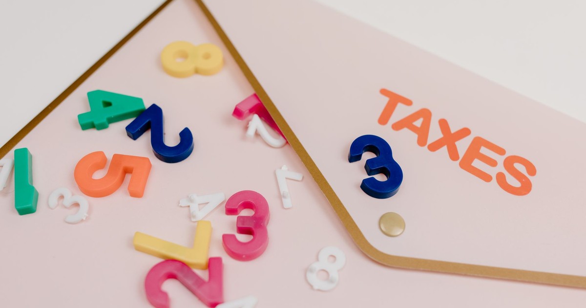 Bright plastic numbers scattered over a tax envelope, symbolizing accounting and finance concepts.