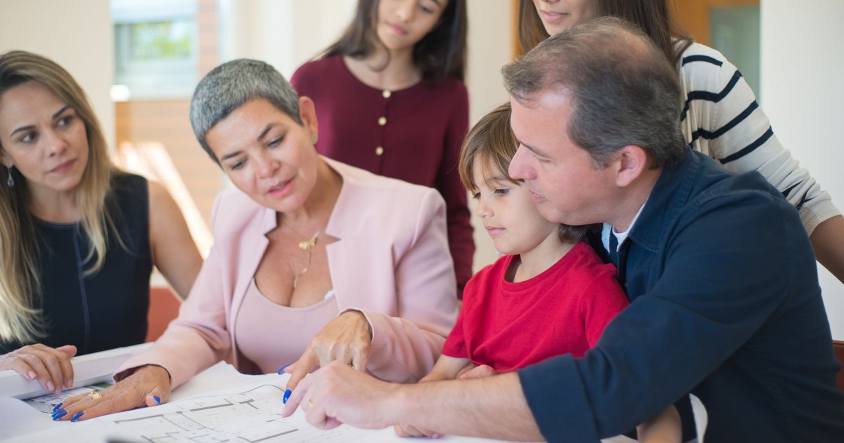 Family meeting with realtor to discuss house plans, emphasizing real estate decision-making.