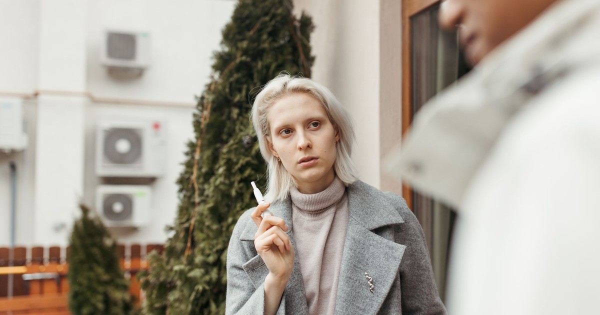 Two adults engaged outdoors, focusing on communication and expression in a casual setting.