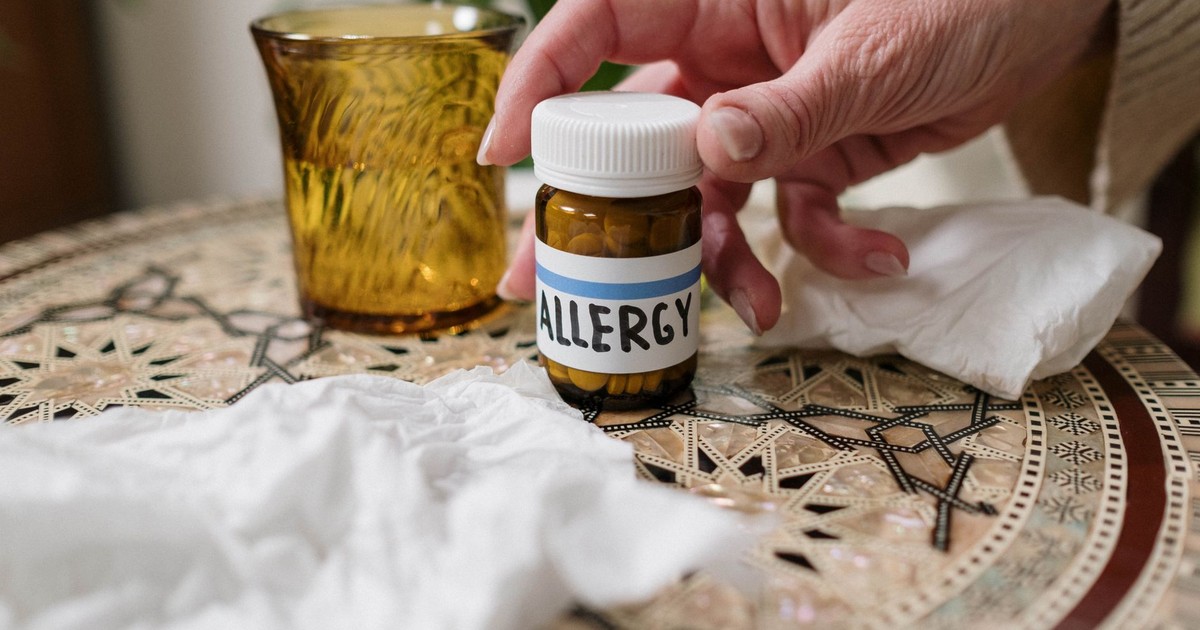 A close-up of allergy medication bottle on table with tissues, ideal for health themes.