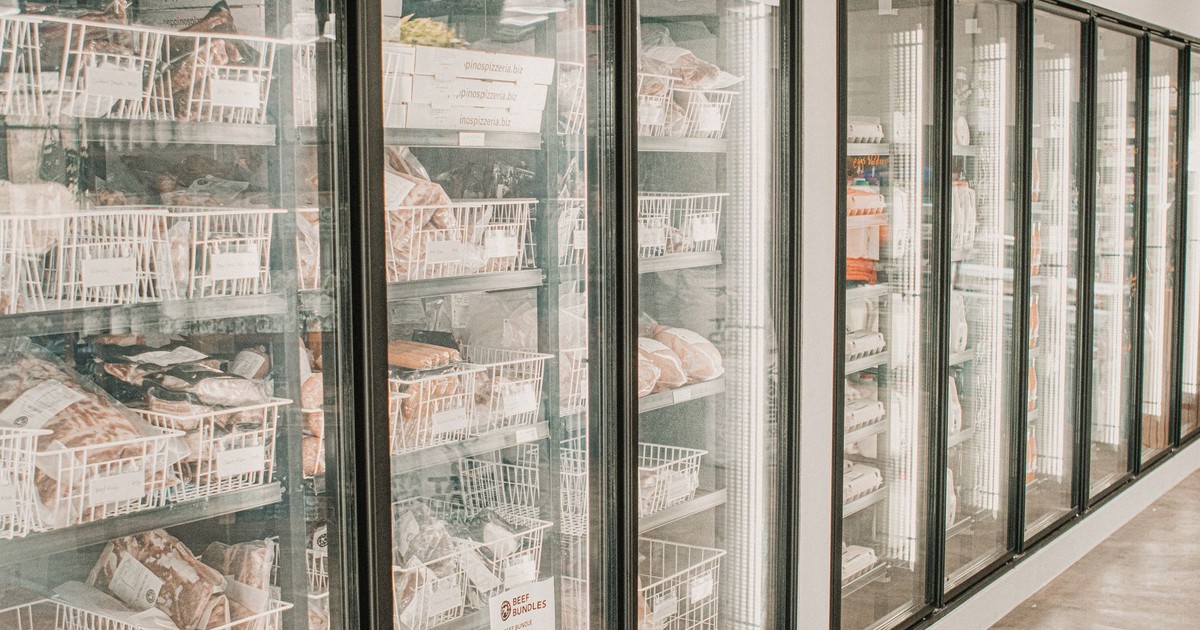 Frozen meats in a retail freezer with transparent doors and organized sections.