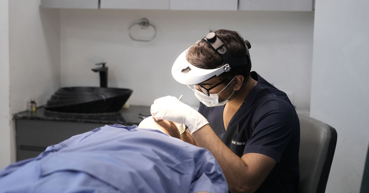 A dermatologist performing a procedure in a clinical setting in Delhi, India.