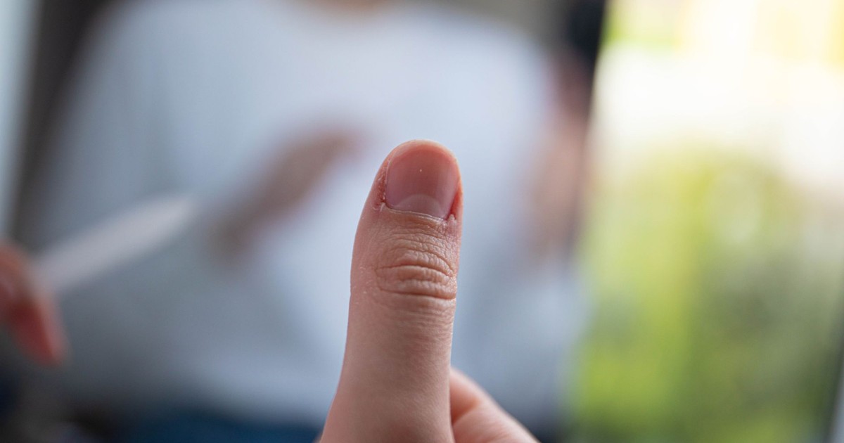 Detailed view of a thumb with a blurred background, showcasing texture and focus.
