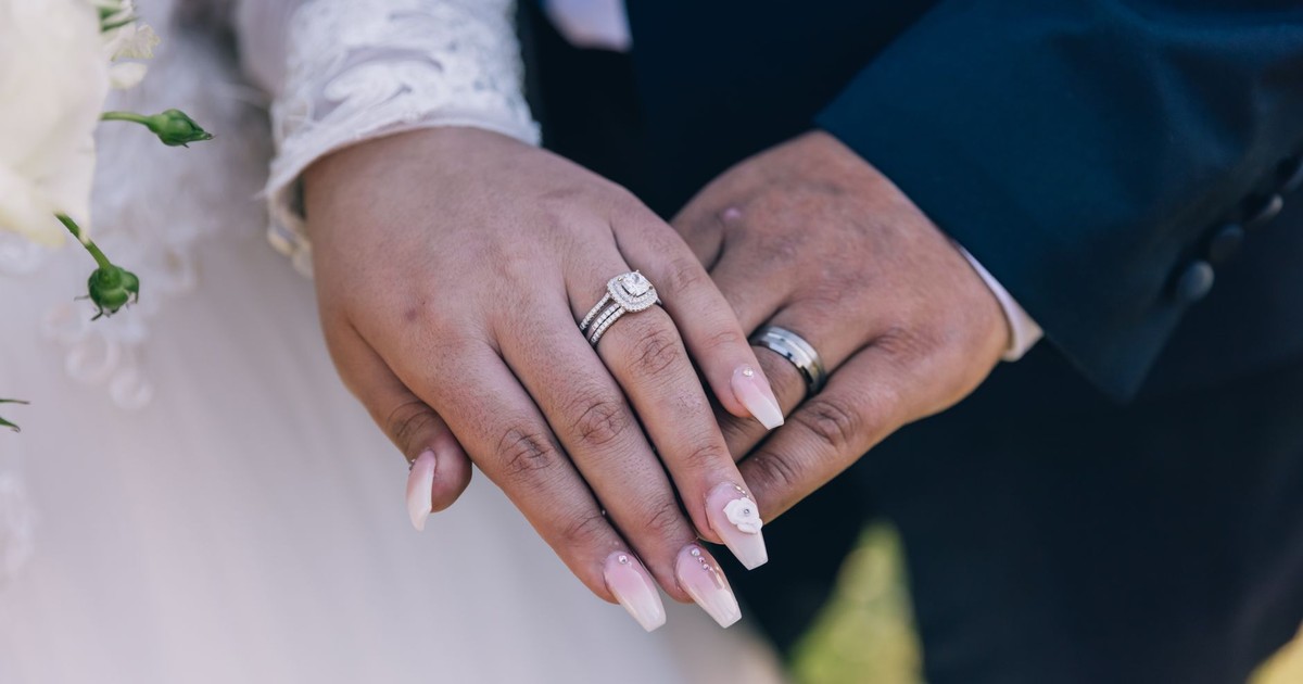 Close-up image of a couple's hands showing off diamond wedding rings, symbolizing love and marriage.