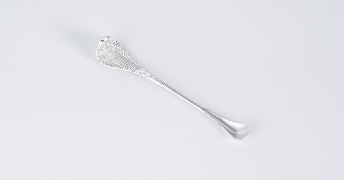 Elegant silver cobra-shaped spoon on a white background showcasing minimalist design.