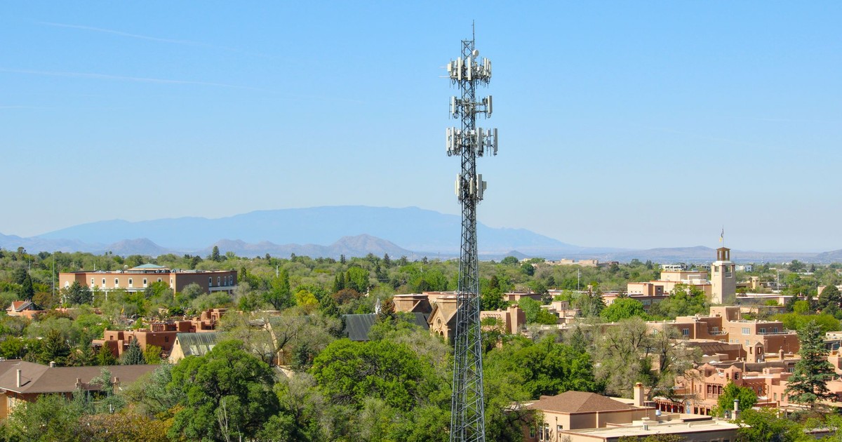 A scenic aerial view of Santa Fe, NM, featuring a cell tower and classic adobe architecture.
