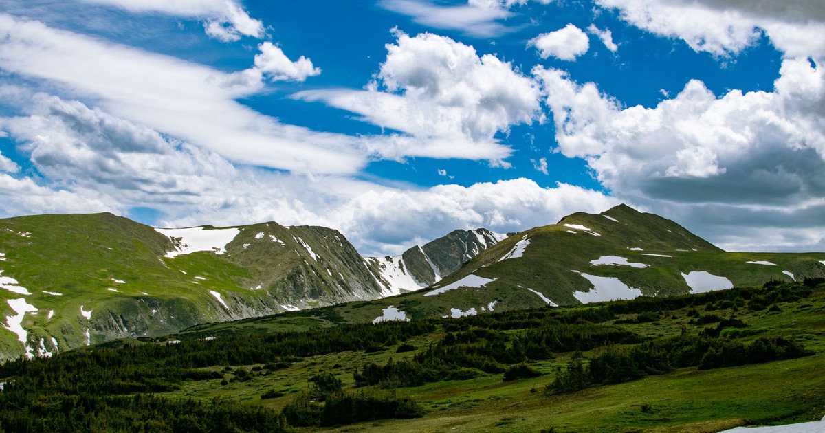 Scenic view of mountains under a clear blue sky with lush greenery, near Denver, CO.