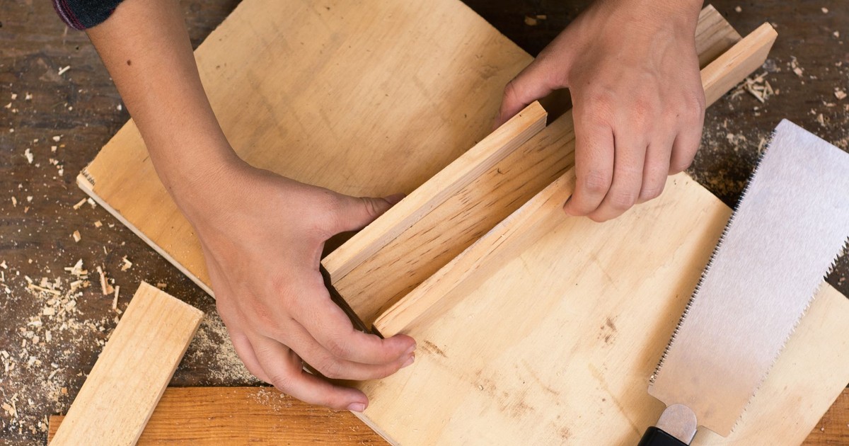 Close-up of hands crafting wood with tools, perfect for DIY carpentry and craft projects.