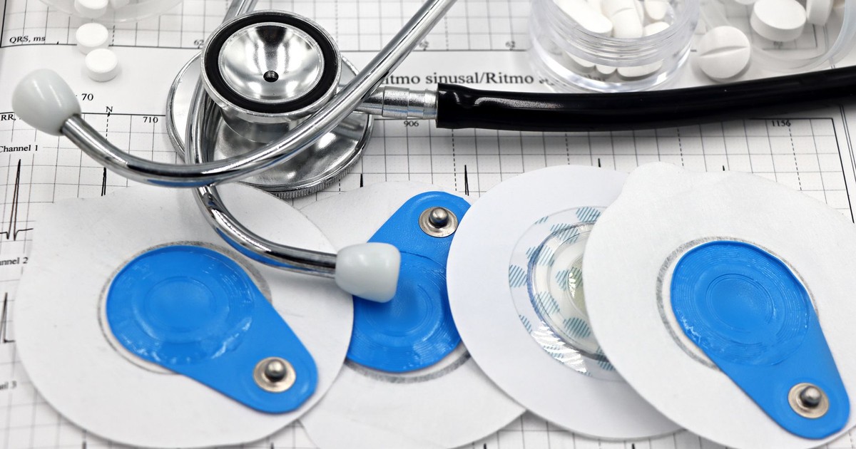 Medical instruments including stethoscope and ECG electrodes on a cardiology chart.