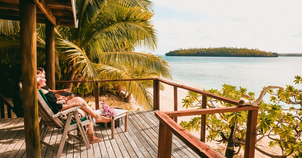 A serene tropical deck overlooking a scenic beach, perfect for relaxation and vacation vibes.